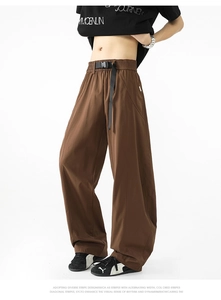 Detalle de pantalones anchos marrón oscuro con cintura elástica y cinturón con hebilla