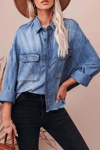 Detailed close-up of blue washed denim shirt featuring front double pockets and metal buttons