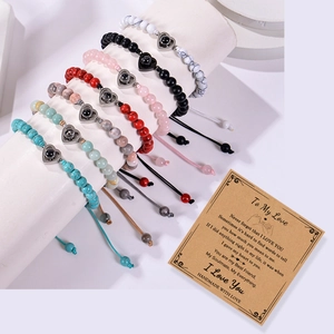 Stone bead couple bracelets with 100 languages heart projection pendant on a display stand