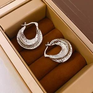 Close-up of silver multi-layer hoop earrings with textured finish in a jewelry box