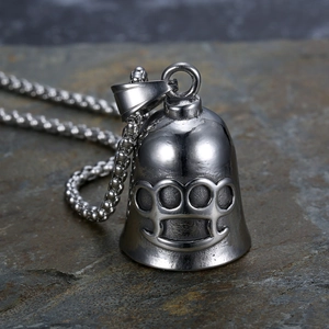 Detailed close-up of punk knuckle duster guardian bell pendant on a stone surface