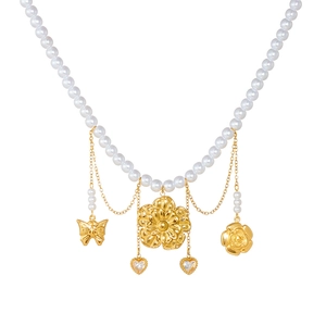 Multilayer pearl necklace with gold-plated butterfly, flower, and heart pendants on white