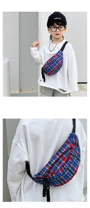Detail of red and blue checkered kids chest bag with black zipper and cord decoration