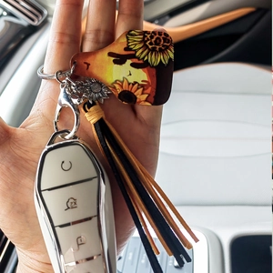 Detail of western cow tag keychain with sunflower leopard print and leather tassels