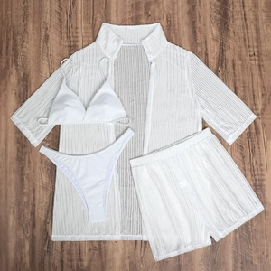 Flat lay of white four-piece mesh swimwear set including bikini, shorts and beach cover-up