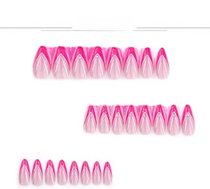 Macro detail of French V-shaped pink gradient press-on nails with glitter and rhinestones