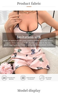 Detail of pink imitation silk nightdress with butterfly print and black spaghetti straps