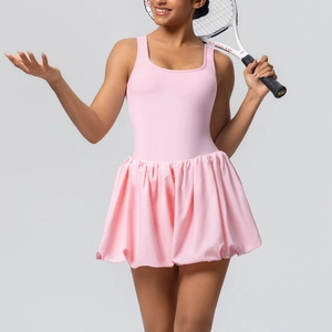 Detail of pink athletic tennis dress featuring racerback top and pleated skirt detail