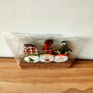 Three 3D wooden Christmas gnomes with 'HOME Sweet GNOME' text on a light wood base