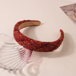 Detail view of red tweed padded headband with gold threads on a decorative shell plate