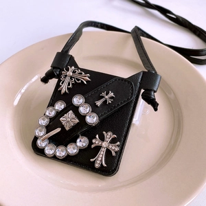 Detail of black pebbled leather mini bag with silver crosses and rhinestone buckle