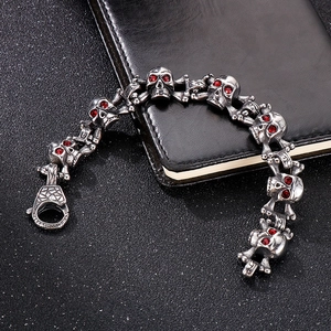 Detailed shot of silver skull bracelet links with red gemstones and large lobster clasp