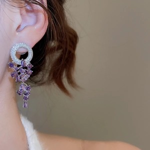 Gros plan de boucles d'oreilles pampilles en zircon violet avec design géométrique argenté