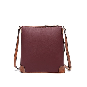 Close-up of wine red lychee texture leather handbag with brown trim and gold zipper