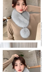 Detail of light gray faux fur scarf with a plush pom-pom and cross-over closure design