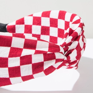 Close-up of red and white checkered fabric headband with a central twisted knot design