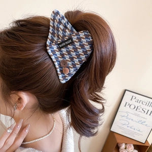 Detail view of British vintage houndstooth hair claw with decorative buttons and label