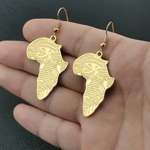 Détail de boucles d'oreilles carte Afrique en acier doré avec gravure Œil d'Horus