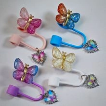 Macro shot of glittery resin butterfly rings with heart pendants in four vibrant colors