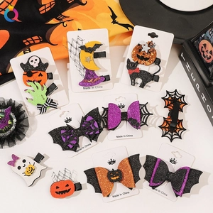 Close-up of Halloween glitter hair clips with pumpkin and ghost motifs on display cards