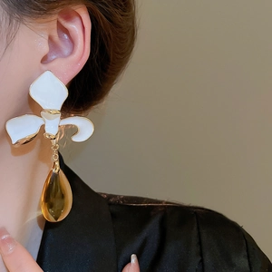 Detail of elegant floral drop earrings with white petals and amber waterdrop pendants