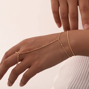 Close-up of an 18K gold double-layered finger bracelet and slim bangle set on hand