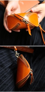 Macro detail of tan veg-tanned leather zipper key pouch with hand-stitched detailing