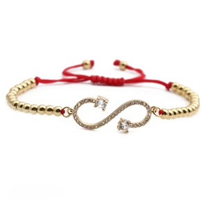 Adjustable red woven rope bracelet with gold infinity charm and sparkling zircons