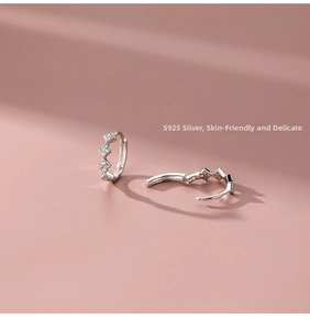 Macro shot of 925 sterling silver hoop earrings with diamond-set rhombic geometric texture