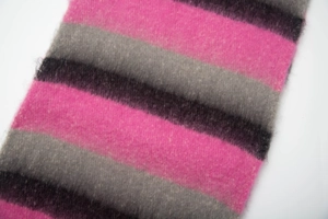 Close-up of pink and grey striped knitted wool scarf showing thick texture and soft fabric