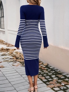 Elegant navy blue knit dress with white stripes, showing back view on an autumn street