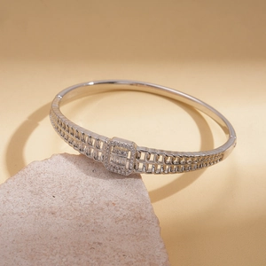 Vue macro d'un bracelet géométrique creux argenté serti de pierres de zircon