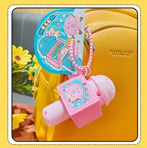 Pink microphone keychain with recording function attached to a yellow leather bag