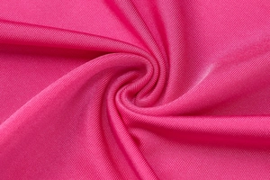 Dettaglio del tessuto a maglia a coste fucsia con drappeggio fluido e fibre sintetiche