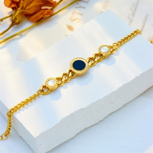 Golden irregular chain bracelet with Roman numeral charms in black and white shell finish