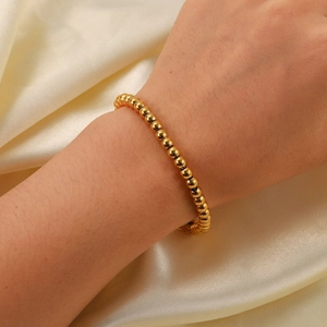 Minimalist 18K gold plated stainless steel bead bracelet worn on a female wrist