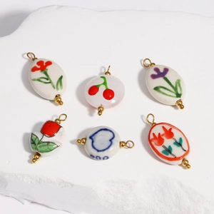 Close-up of assorted ceramic pendants with hand-painted floral and cherry patterns