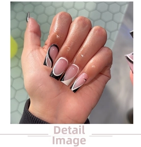 Close-up of black and white geometric line patterns on long coffin-shaped press-on nails