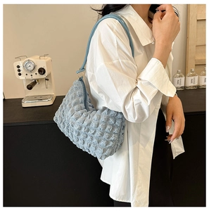 Close-up of light blue bubble textured tote bag shoulder strap and puffy fabric detail