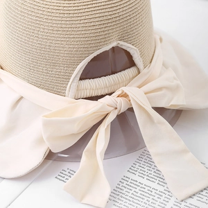 Women's UV protection straw sun hat with large cream bow and adjustable back detail