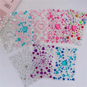 Close-up of 3D acrylic heart and round crystal gem stickers in various vibrant colors