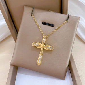 Dettaglio collana a croce ritorta dorata con pavé di cristalli in confezione regalo