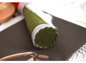 Close-up of thick green felt Christmas gnome with silver glitter and hand-stitched detail
