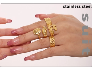 Set of five gold PVD coated stainless steel textured rings worn on hand in a detail view