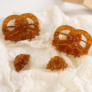Ensemble détaillé de pinces à cheveux en acétate ambré aux formes de bretzel et croissant