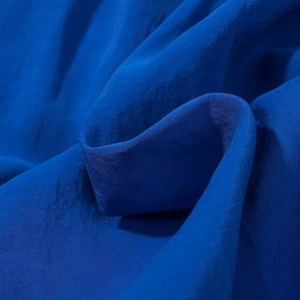 Detail of royal blue midi dress showing smooth silk-like fabric texture and draping