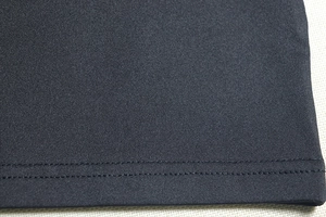 Detailed close-up of high-quality double-stitched hem on a black knitted bodycon dress