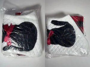 Close-up of white quilted Christmas stocking with black cat patch in plastic packaging
