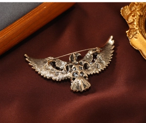 Detailed view of the vintage bronze eagle brooch with eagle wings on brown silk fabric