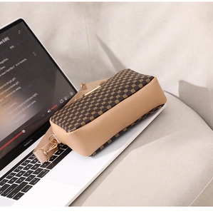 Detail of vintage patterned crossbody camera bag on a laptop with soft lighting